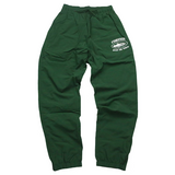 Corteiz Shukushuku green track pants with logo on the side.