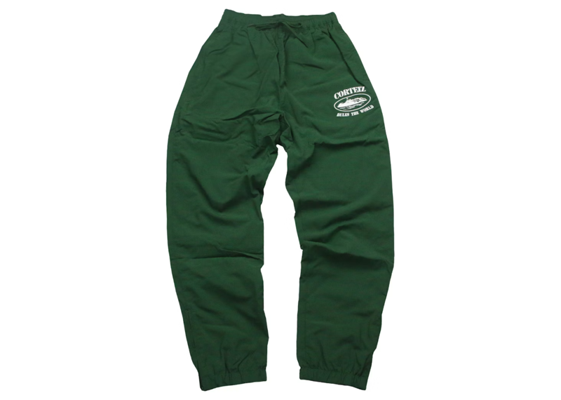 Corteiz Shukushuku green track pants with logo on the side.