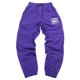 Corteiz Shukushuku Track Pants in grape purple.