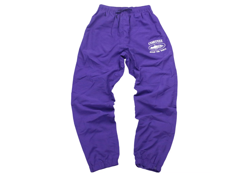 Corteiz Shukushuku Track Pants in grape purple.