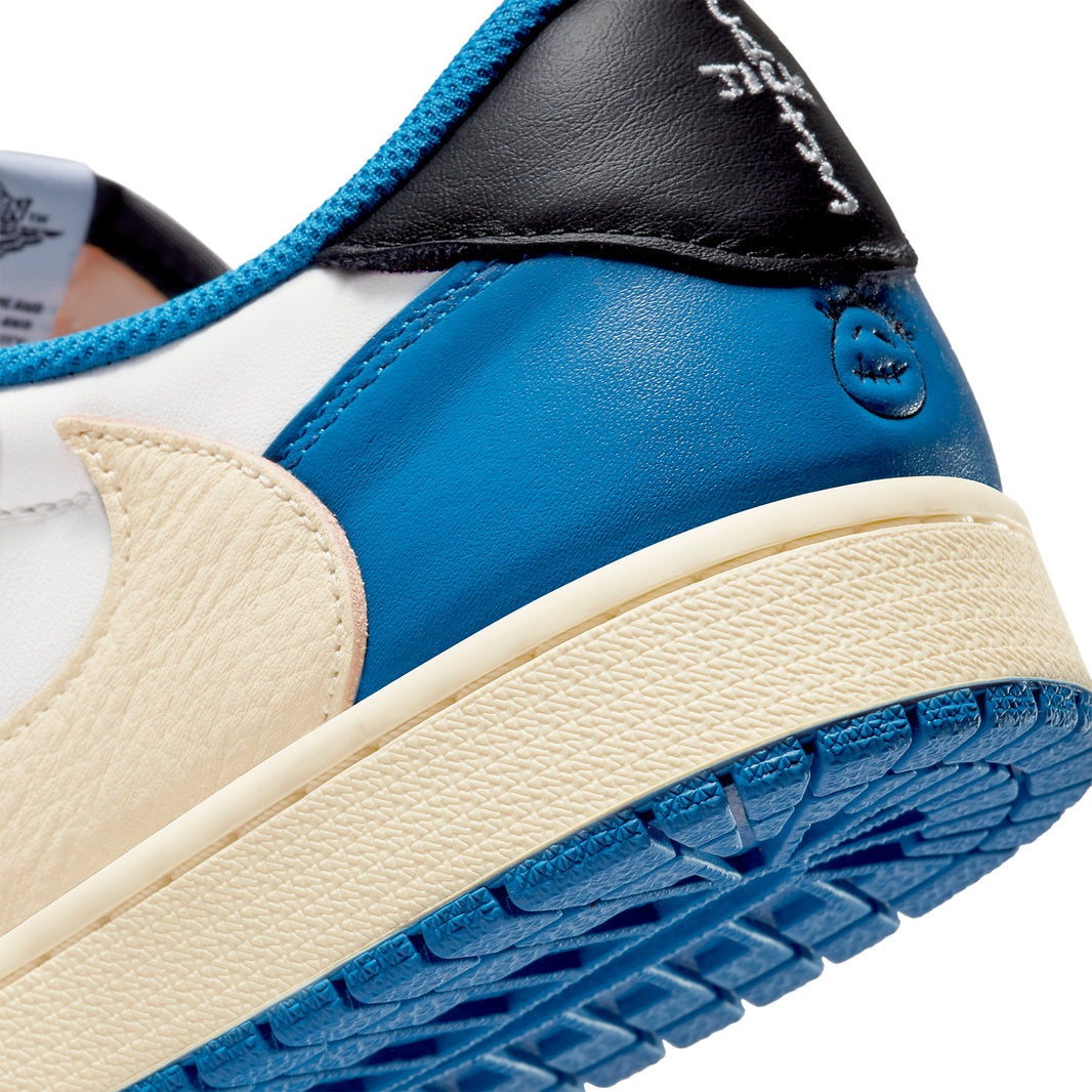 Air Jordan 1 Retro Low x Travis Scott Fragment sneaker, featuring premium white leather, black suede overlays, and bold blue accents.