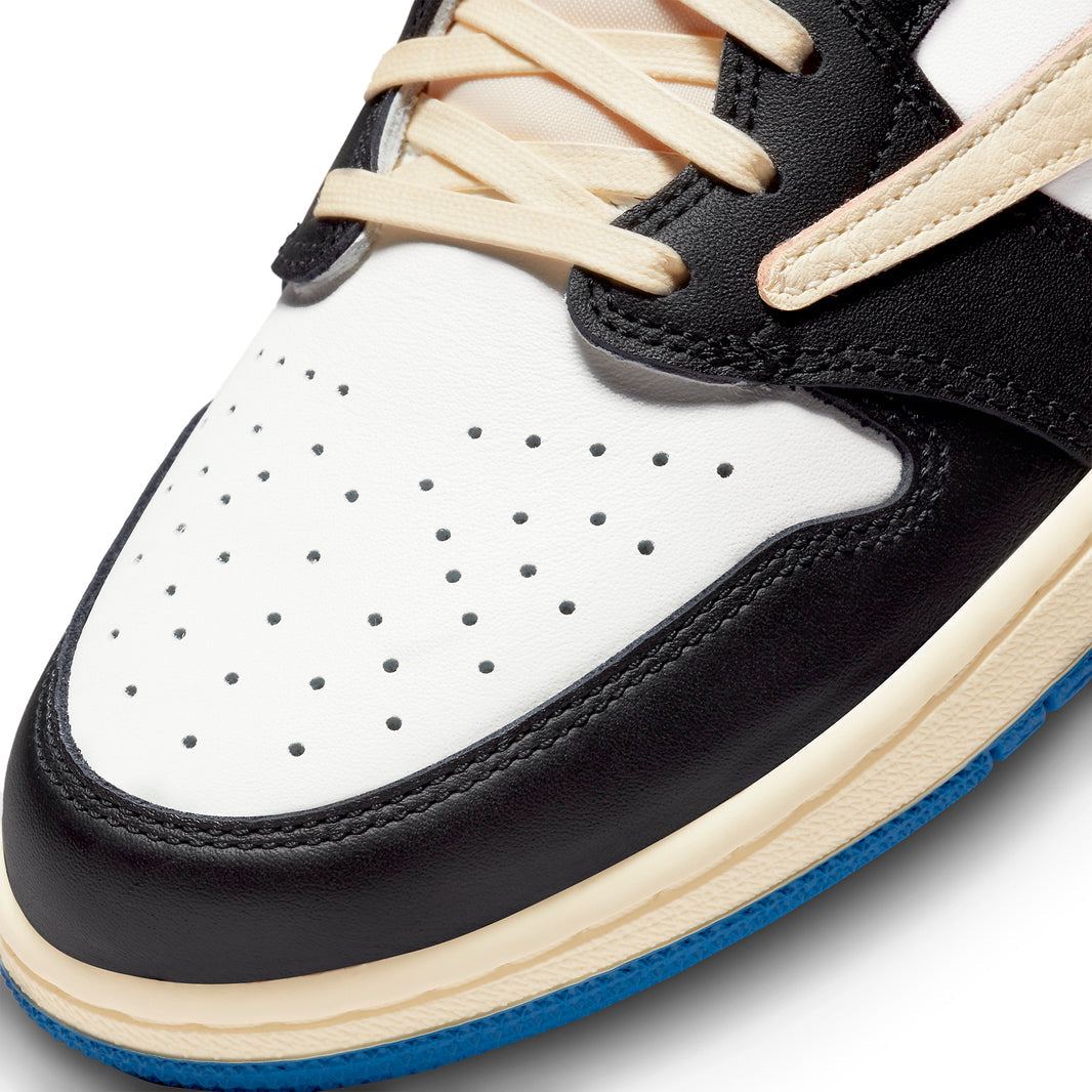 Air Jordan 1 Retro Low x Travis Scott Fragment sneaker, featuring white leather, black suede overlays, and blue accents.
