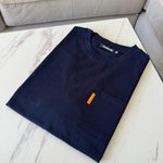 Studio By Charles navy pocket tee neatly folded on white marble table next to beige sofa