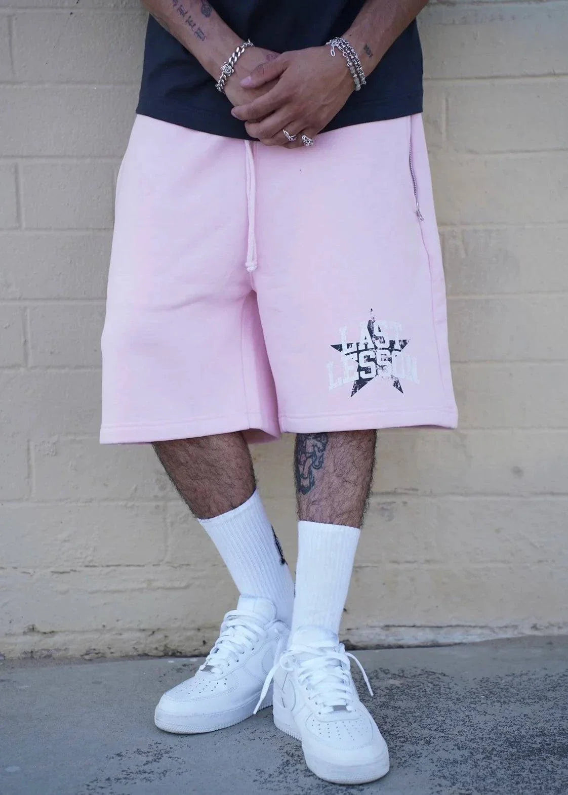 Pink Last Lesson All-Star Shorts worn with white sneakers.