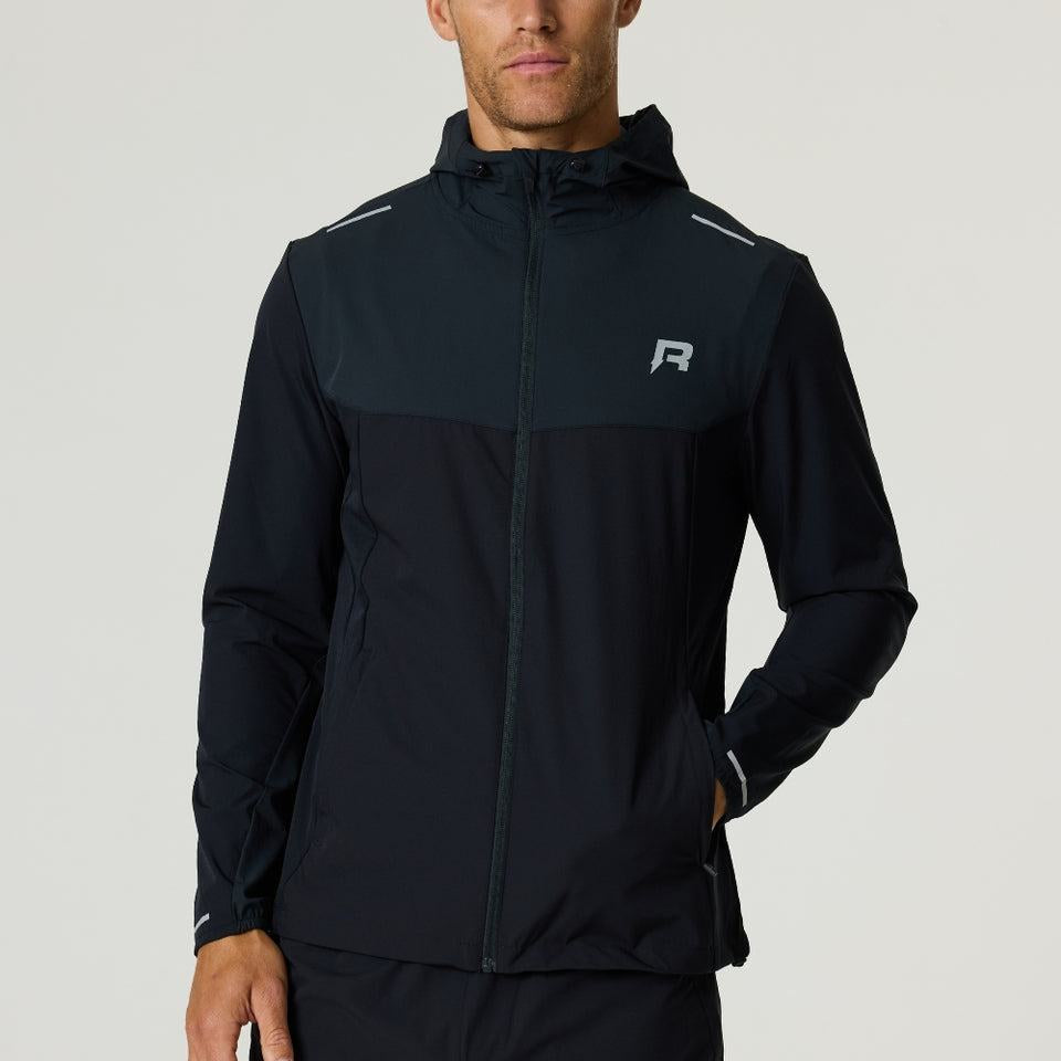 Man wearing black Reprimo Flight Windbreaker with hood and zip pockets, designed for lightweight weather protection and breathability