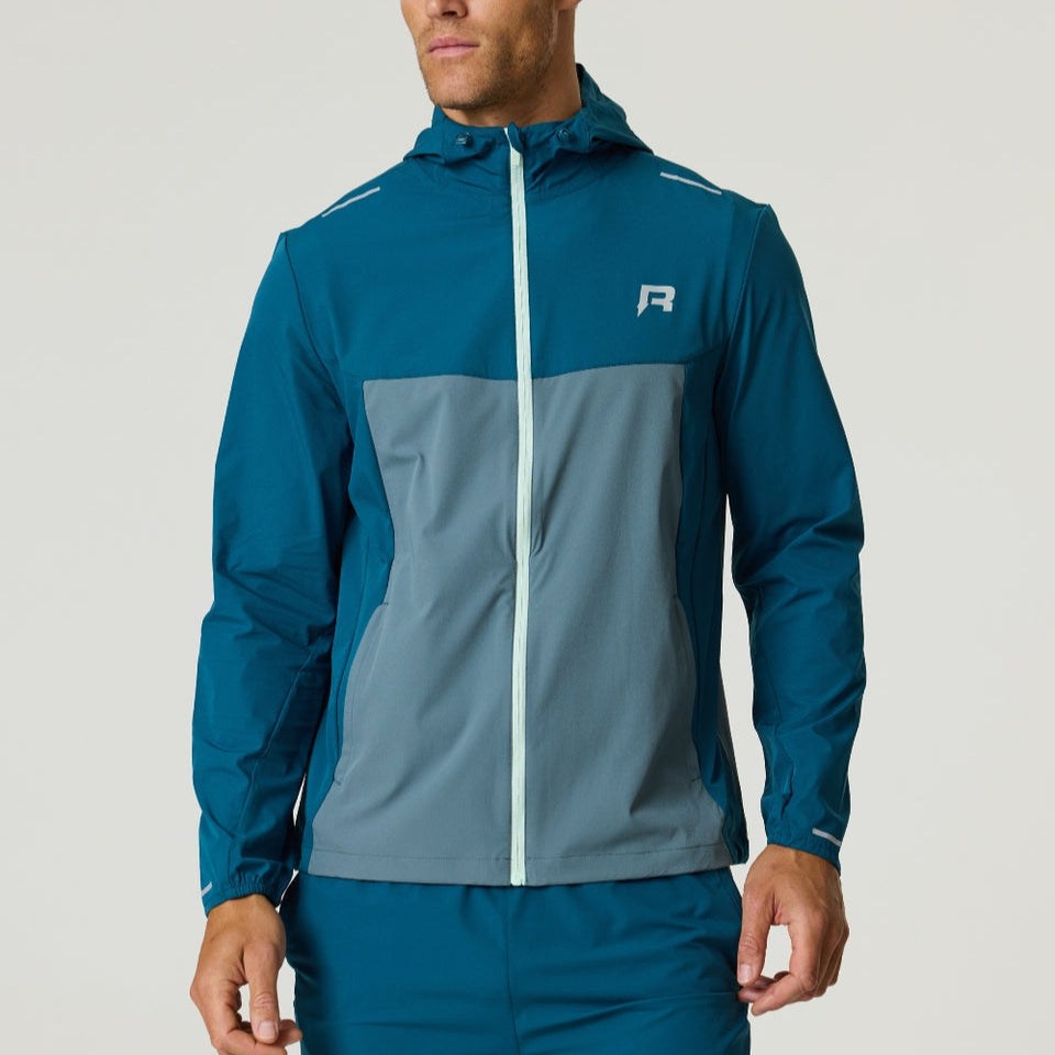 Men's Reprimo Flight Windbreaker in tidal teal and blue steel with zip pockets and hood, lightweight wind and rain resistant jacket.