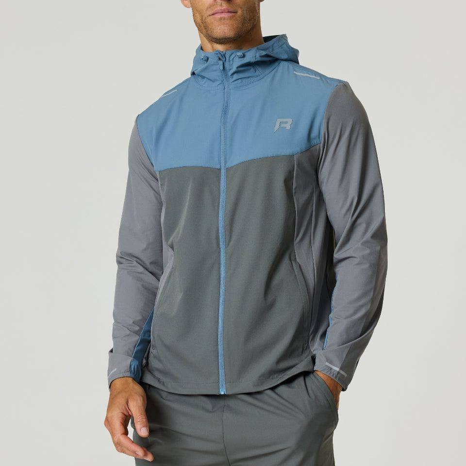 Man wearing Reprimo Flight Windbreaker in Air Force Blue and Gunmetal with hood and zip pockets