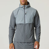 Man wearing a slate and light grey Reprimo Summit Windbreaker with hood and full zipper, designed for lightweight comfort and active movement