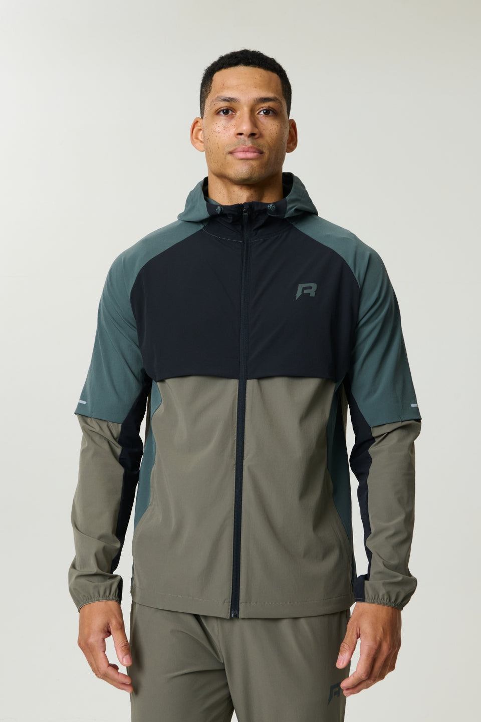 Reprimo Vortex Windbreaker in dark moss and grey velvet with ergonomic design and reflective details