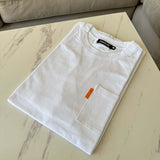 White Studio By Charles White pocket tee neatly folded on a marble table