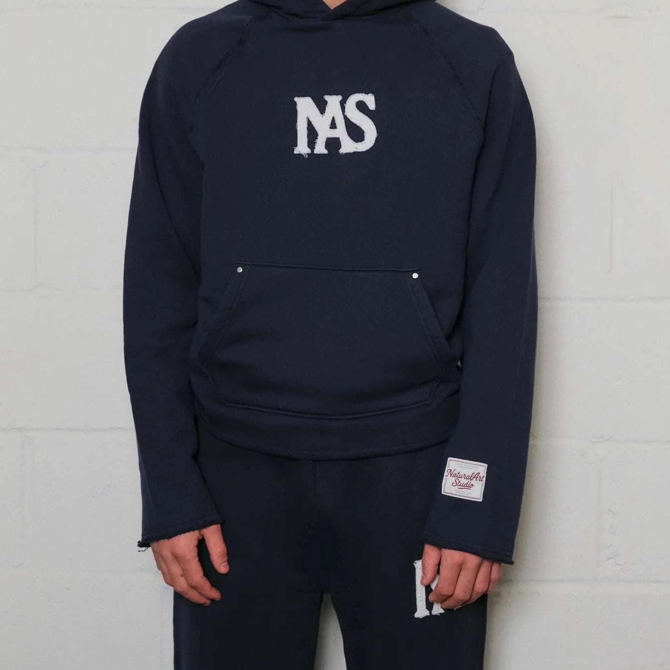 Natural Art Studio navy hoodie with appliqué logo and raw edges in a boxy oversized fit