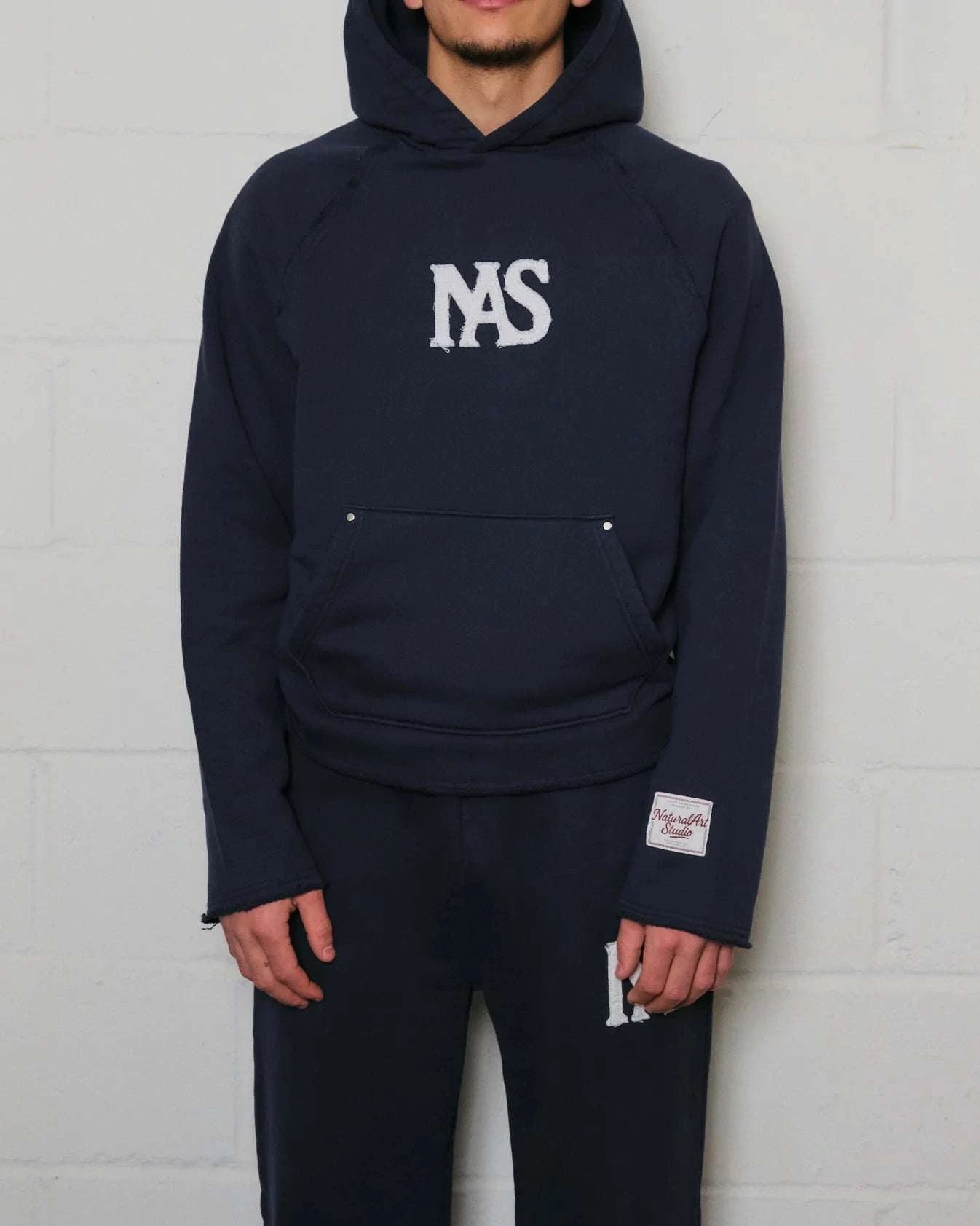Natural Art Studio navy hoodie with appliqué logo and raw edges in a boxy oversized fit