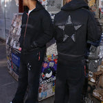 Black hoodie with star appliqué design on back, modeled by two people in an urban setting, Last Lesson Hoodie.