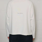 Back view of Natural Art Studio white appliqué long sleeve cotton shirt with screen print logo and boxy fit