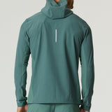 Man wearing botanical pine Reprimo Glide Jacket viewed from the back with hood up