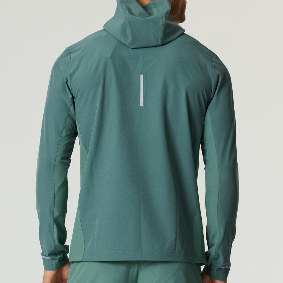 Man wearing botanical pine Reprimo Glide Jacket viewed from the back with hood up