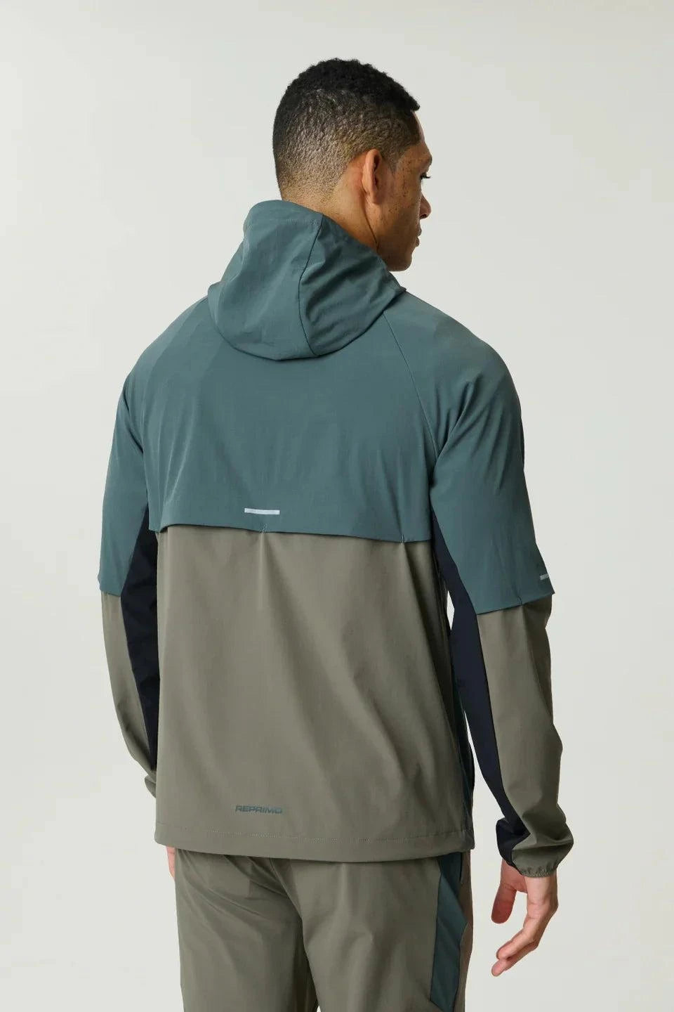 Reprimo Vortex Windbreaker in dark moss and grey velvet with ergonomic panels and reflective details