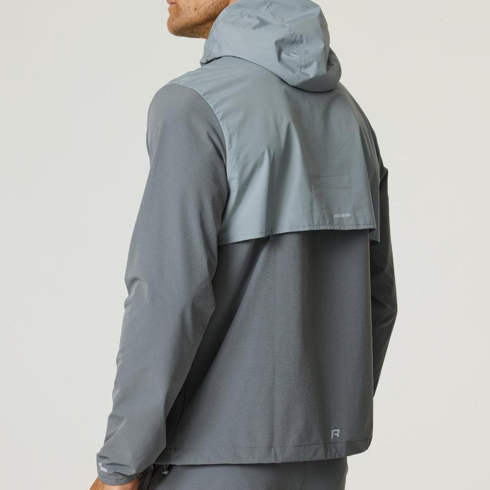 Man wearing slate and light grey Reprimo Summit Windbreaker jacket with hood, shown from the back and side.