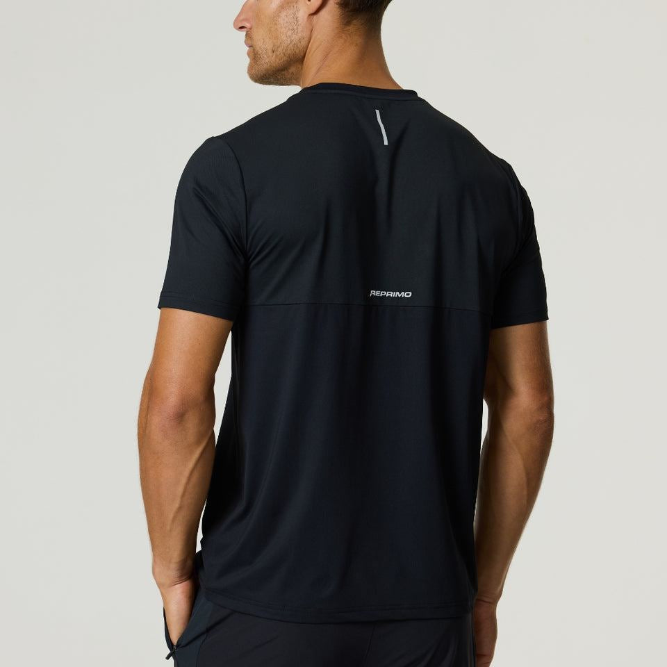 Athlete wearing black Reprimo Flight T-Shirt with reflective strip on back, breathable lightweight athletic fit design