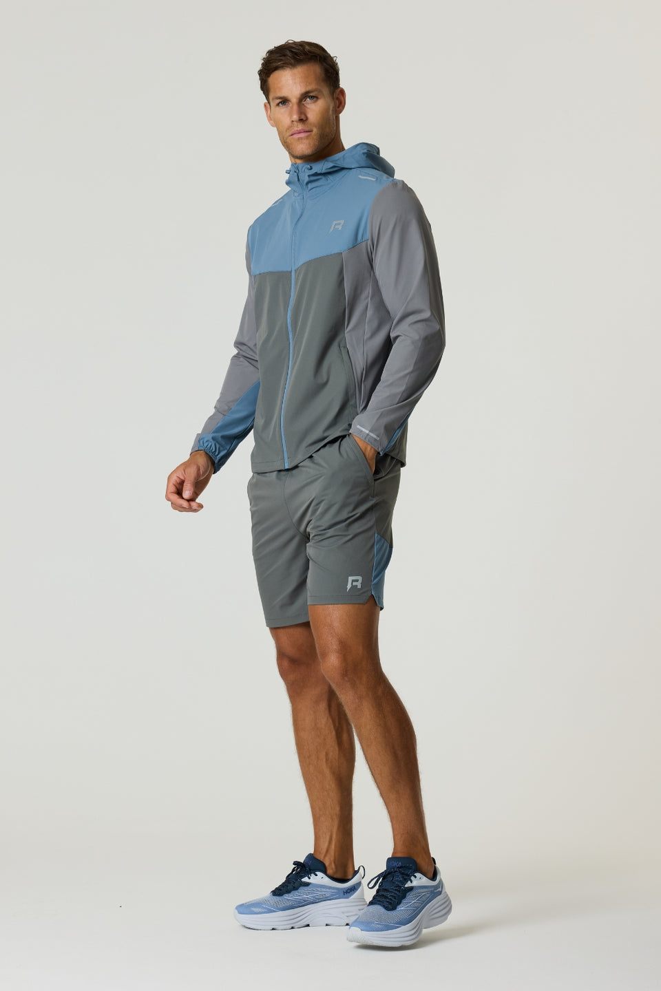 Reprimo Flight Windbreaker in Air Force Blue and Gunmetal, lightweight polyamide jacket with hood, zip pockets, and breathable back vent for weather protection.
