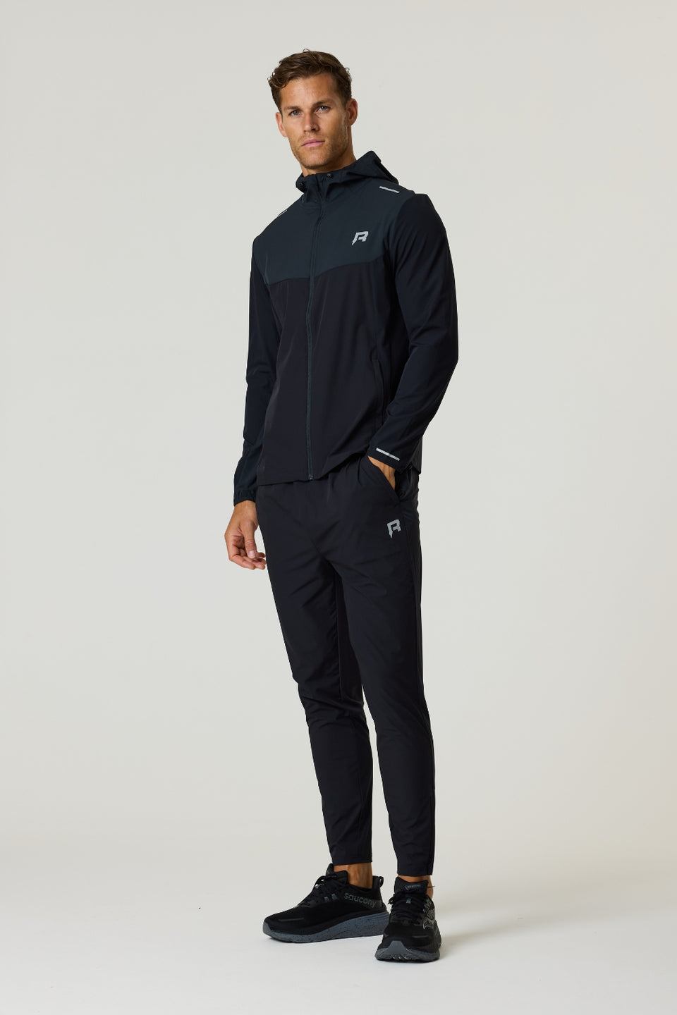 Reprimo Flight Windbreaker in black and meteorite color, lightweight polyamide jacket with hood, zip pockets, and breathable back vent for outdoor activities.