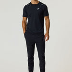 Male model wearing black Reprimo Flight T-Shirt and black athletic pants with black sneakers, standing against a plain light background.