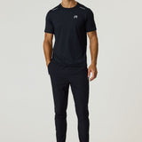Male model wearing black Reprimo Flight T-Shirt and black athletic pants with black sneakers, standing against a plain light background.