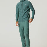 Man wearing Reprimo Glide Pants in botanical pine with tapered fit, textured breathable fabric, and seam-embedded pockets.