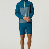 Man wearing Reprimo Flight Windbreaker in tidal teal and blue steel with matching shorts and running shoes