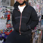 Last Lesson Appliqué Black Hoodie worn by model in urban setting.