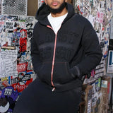 Last Lesson Appliqué Black Hoodie worn by model in urban setting.