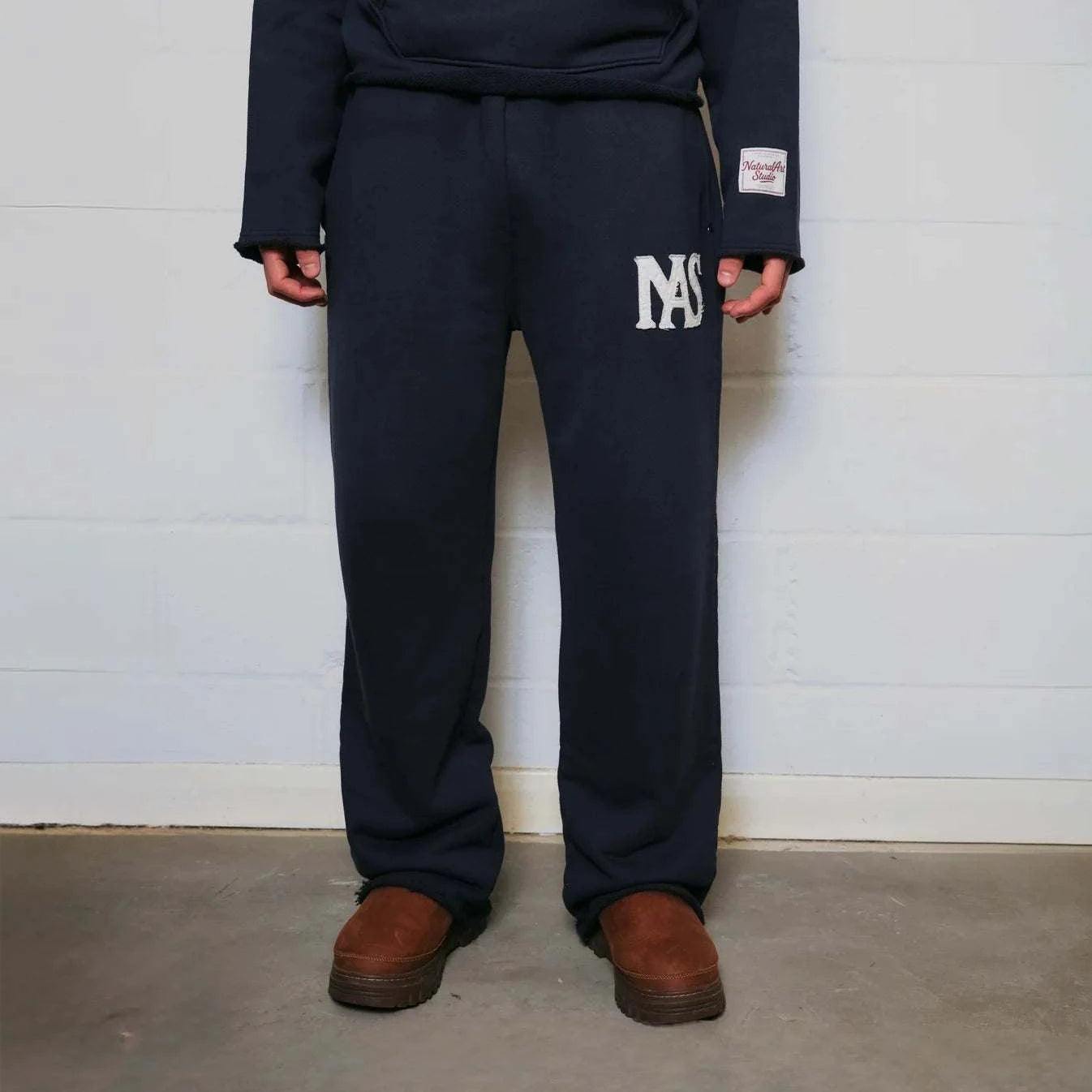 Natural Art Studio navy sweatpants with appliqué logo, elastic waistband, and relaxed oversized fit