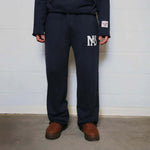 Natural Art Studio navy sweatpants with appliqué logo, elastic waistband, and relaxed oversized fit