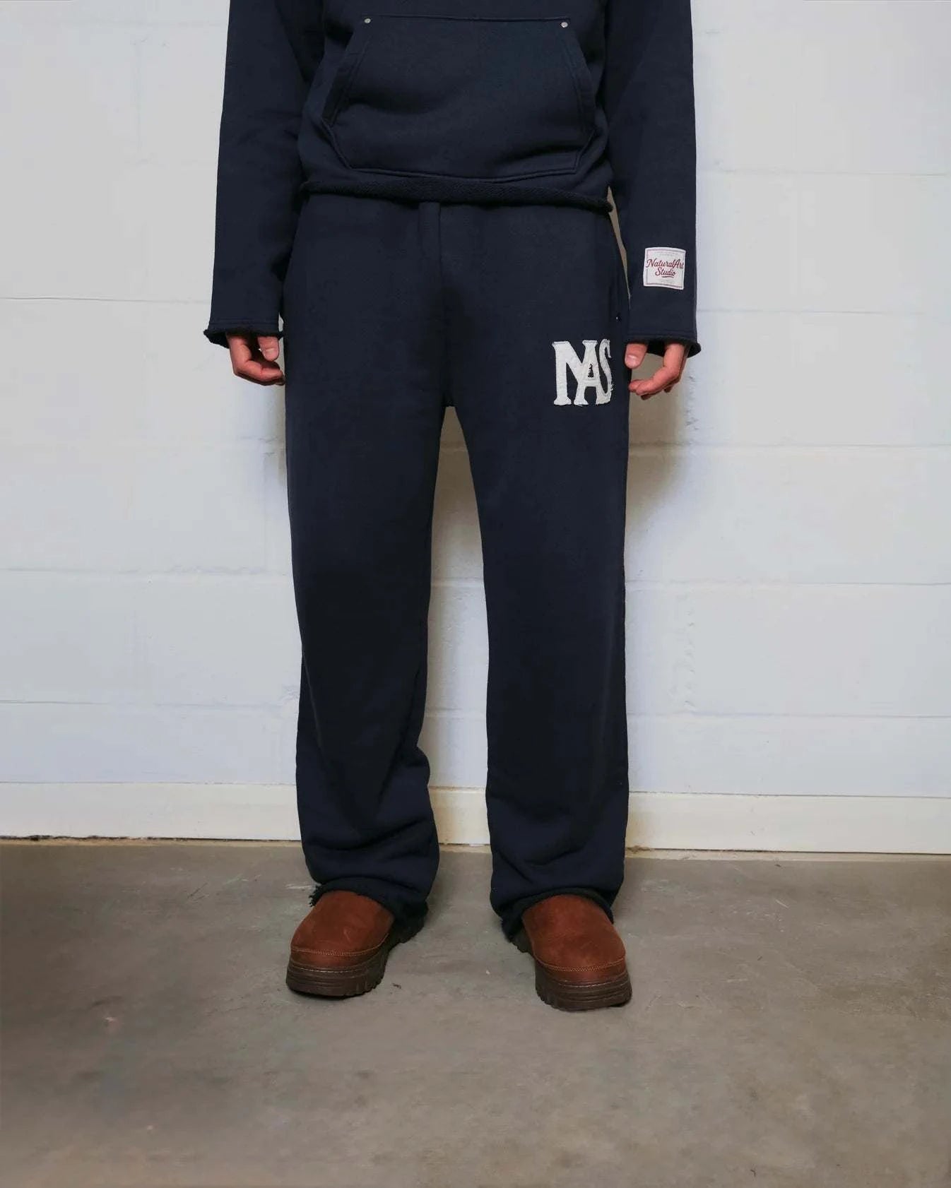 Natural Art Studio navy sweatpants with appliqué logo, elastic waistband, and relaxed oversized fit