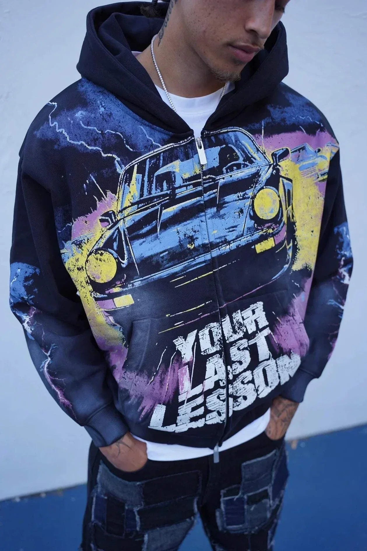 Last Lesson Black Car Hoodie with graphic car design and bold text worn by model