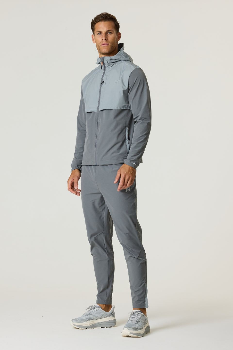 Athlete wearing Reprimo Summit Pant in slate and light grey with matching hoodie and sneakers