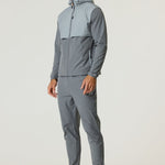 Athlete wearing Reprimo Summit Pant in slate and light grey with matching hoodie and sneakers