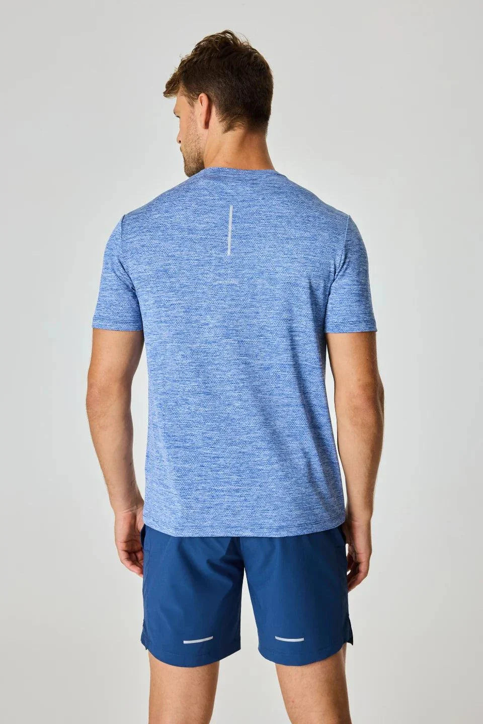 Reprimo Pulse T-Shirt in indigo worn by a man, back view.