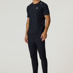 Male model wearing black Reprimo Flight Pants with reflective strips and functional pockets, paired with black athletic shirt and shoes.