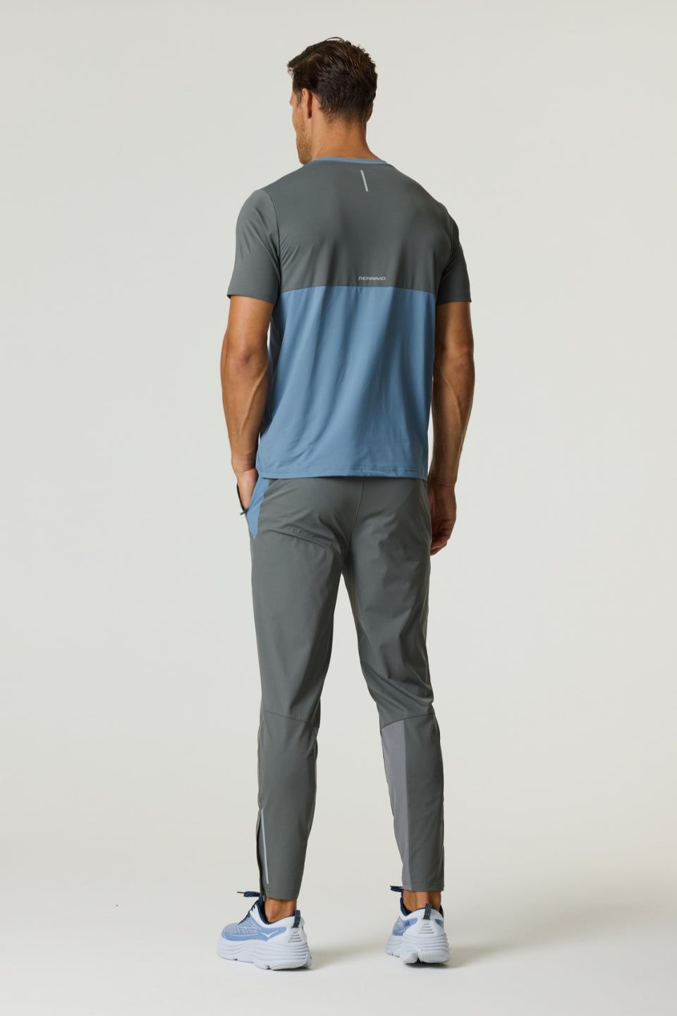 Man wearing Reprimo Flight Pants in Air Force Blue and Gunmetal with breathable, lightweight design and reflective strips for enhanced visibility.