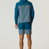 Man wearing Reprimo Flight Windbreaker in tidal teal and blue steel from the back, showcasing lightweight weather-resistant jacket with hood and zippered pockets.