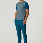 Athlete wearing Reprimo Flight Pants in tidal teal with functional pockets and reflective strips for performance and comfort