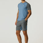 Man wearing Reprimo Flight Shorts in Air Force Blue and Gunmetal with breathable fabric and secure side pockets.