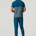 Rear view of man wearing Reprimo Flight T-Shirt in tidal teal and blue steel with reflective strips and athletic fit