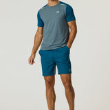 Athletic man wearing Reprimo Flight Shorts in tidal teal and blue steel with matching t-shirt and sneakers.