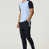 Athlete wearing black Reprimo Flight Pants with side pockets and reflective strips, paired with a light blue and black short-sleeve shirt.
