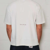 Back view of Natural Art Studio white cotton tee with red printed logo and boxy fit