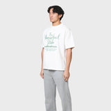 White ANNIE HOOD FACTORY T-SHIRT made of 280gsm cotton with a relaxed fit, modeled by a 6'0" person wearing size M