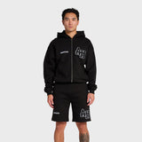 Man wearing black ANNIE HOOD College zip hoodie and matching shorts with double embroidery logo