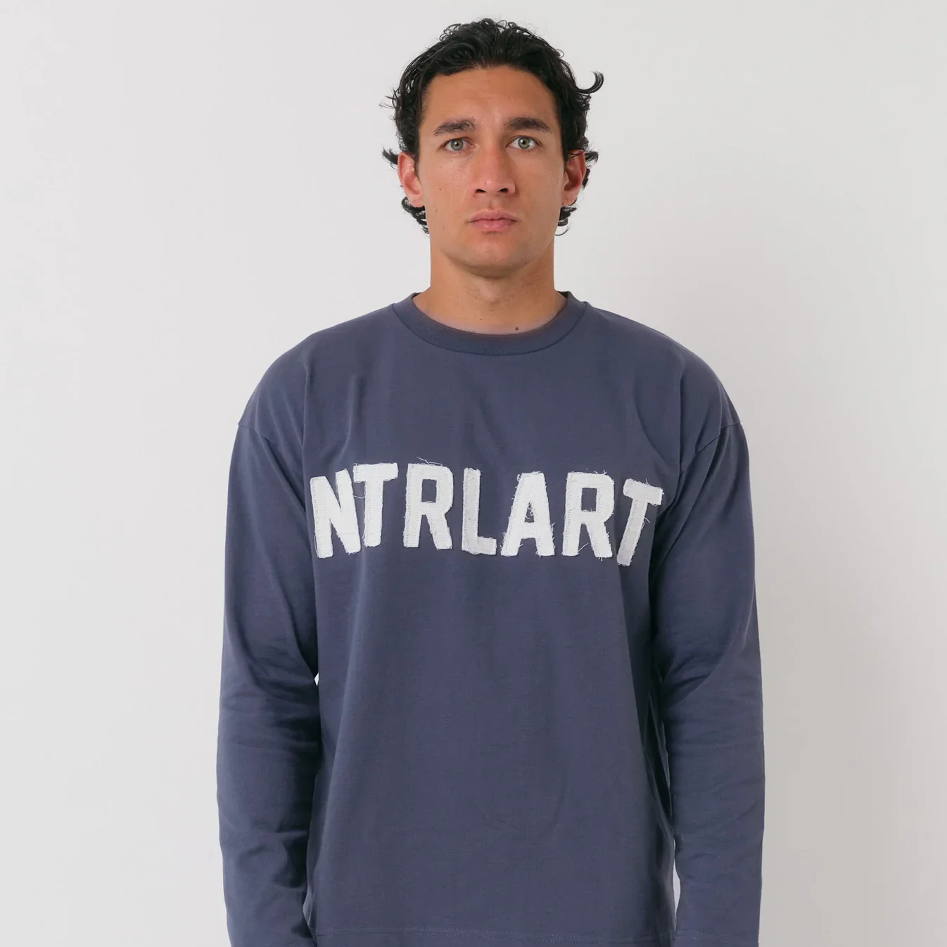 Navy long sleeve with distressed appliqué front logo, boxy fit, oversized dropped shoulder.